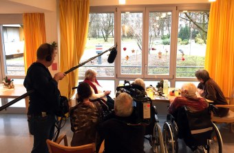 Senioren sitzen am Fenster und werden vom BR-Team gefilmt | © Kathrin Lichtenauer