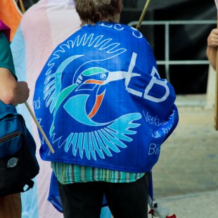 LBV Fahne mit dem dreifarbigen alten Logo wird von einer Frau als Decke benutzt | © LBV