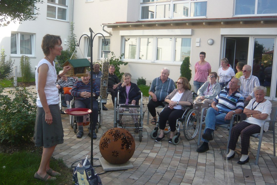Kathrin Lichtenauer besucht ein Seniorenheim, sie erklärt einer Gruppe Senioren eine Futterstelle | © LBV