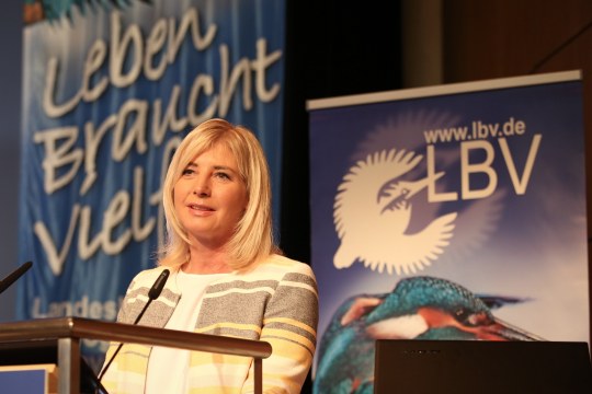 Umweltministerin Ulrike Scharf spricht vor einem Pult in ein Mikrofon. Im Hintergrund sieht man ein LBV-Banner | © Claudia Becher