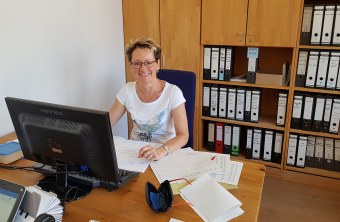 Ehrenamtliche Sabine Schober sitzt in einem Büro am PC vor einem Bildschirm. Hinter ihr sind viele Regale mit vielen Ordnern | © LBV