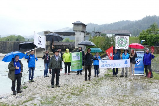 13 VertreterInnen der Organisationen zum Schutz der Oberen Isar, man sieht Menschen mit Bannern der verschiedenen Organisationen, so wie z.B. LBV, WWF, DAV und Bund Naturschutz | © Michael Schödl